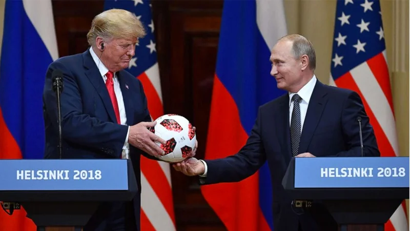 President Donald Trump receives a soccer ball from Russian President Vladimir Putin during their joint press conference at the Helsinki 2018 summit.