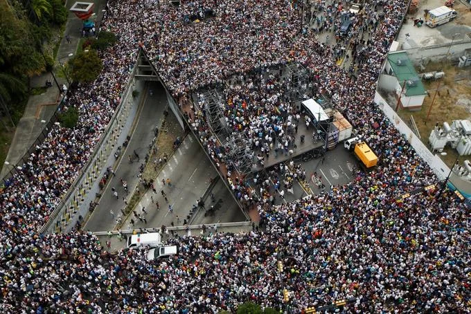 Massive opposition demonstrations flood the streets of Caracas during the 2019 Venezuelan presidential crisis.