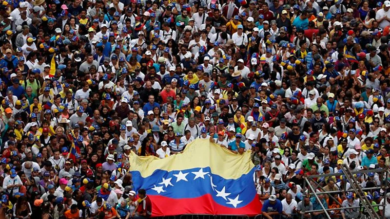 Venezuelan citizens gather en masse during the 2019 political crisis, waving the national flag in support of the opposition.