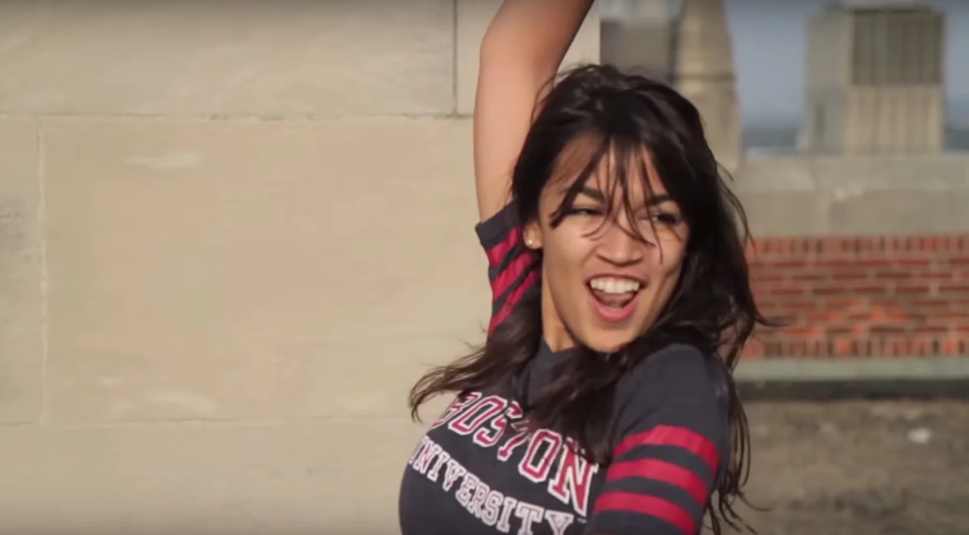 A still from the resurfaced Boston University rooftop dance video that inspired the meme, showing Alexandria Ocasio-Cortez recreating the iconic dance sequence from The Breakfast Club.