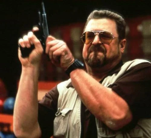 The original scene from The Big Lebowski featuring Walter Sobchak brandishing a pistol, which became the basis for the 'Am I the Only One Around Here' image macro.