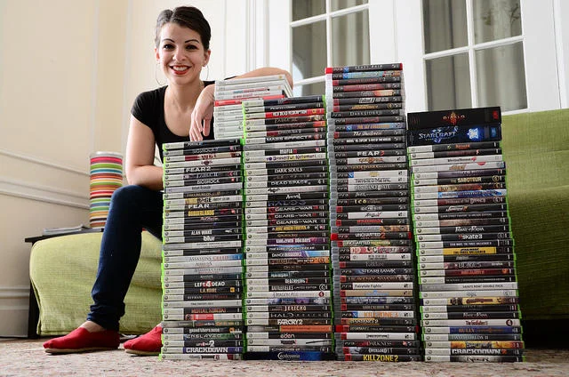 Sarkeesian with the collection of video games used as research for her Tropes vs. Women in Video Games series.