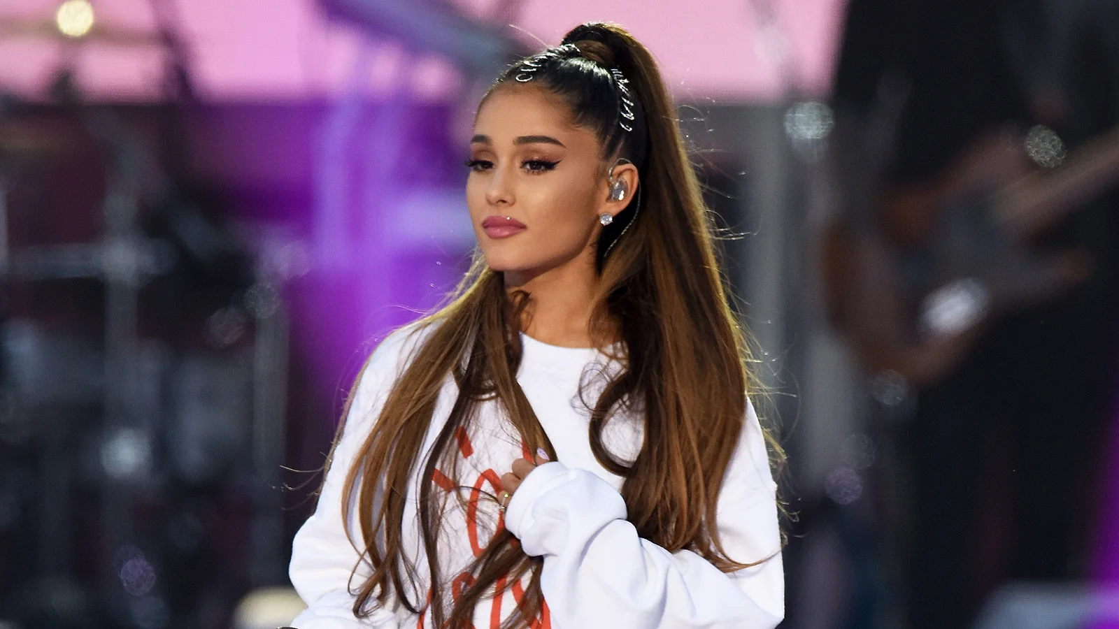 Ariana Grande performing with her signature high ponytail, a look widely associated with the pop singer.