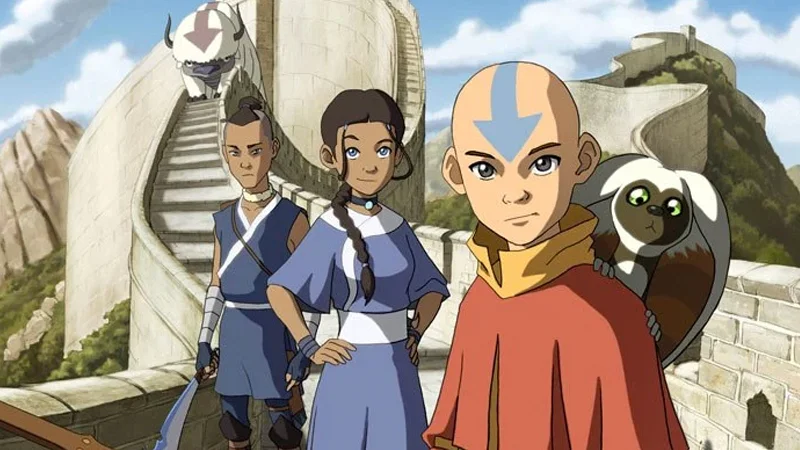 Promotional artwork from Nickelodeon's Avatar: The Last Airbender featuring Team Avatar — Aang, Katara, and Sokka — along with Appa and Momo.