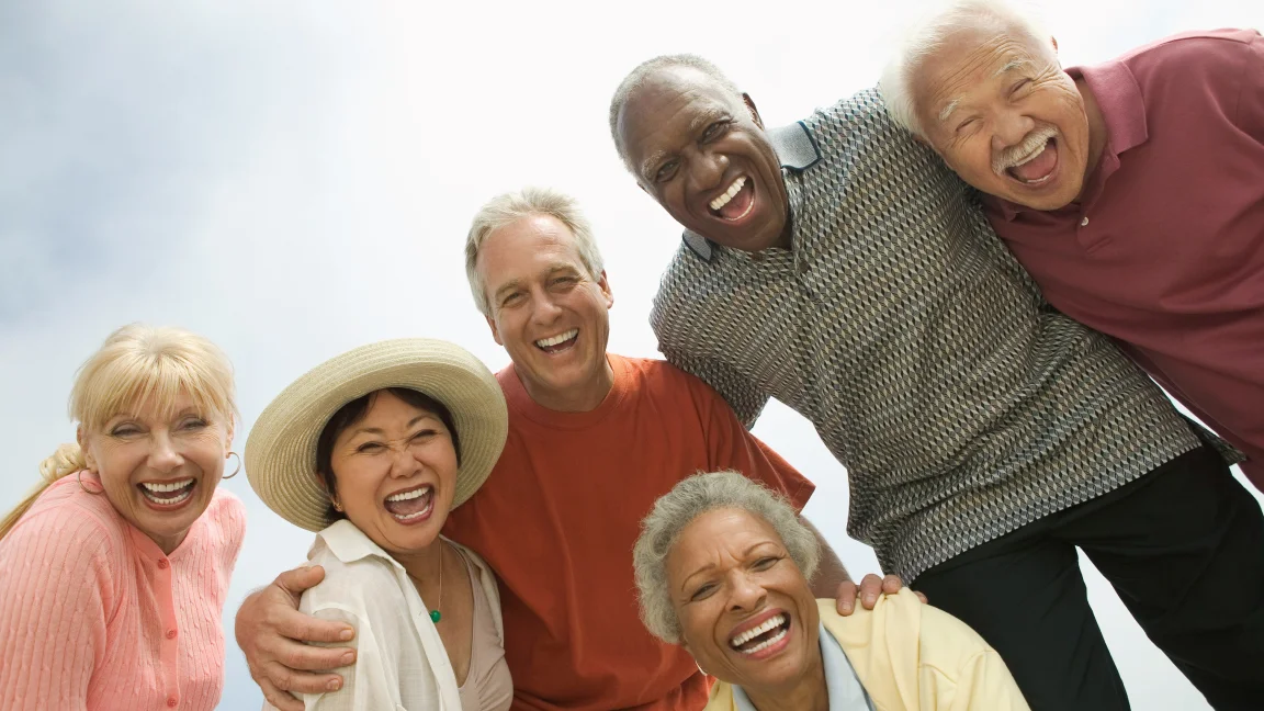 A stock photo of smiling Baby Boomers, often used as a visual shorthand for the generation in memes and articles.