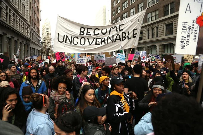 A large protest crowd rallies behind a 'Become Ungovernable' banner, showing the phrase's adoption as a rallying cry at political demonstrations.