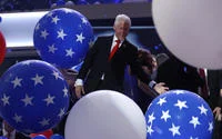 Clinton's playful reaction surrounded by balloons.
