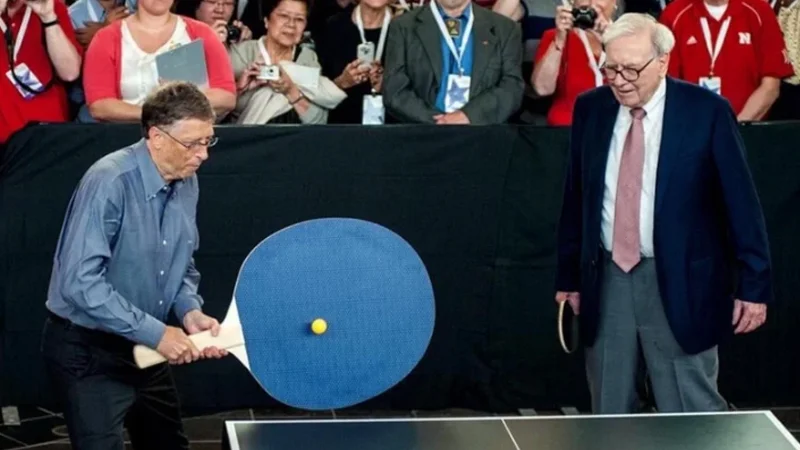 The original photograph of Bill Gates wielding a comically oversized ping pong paddle in a match against Warren Buffett at a Berkshire Hathaway event.