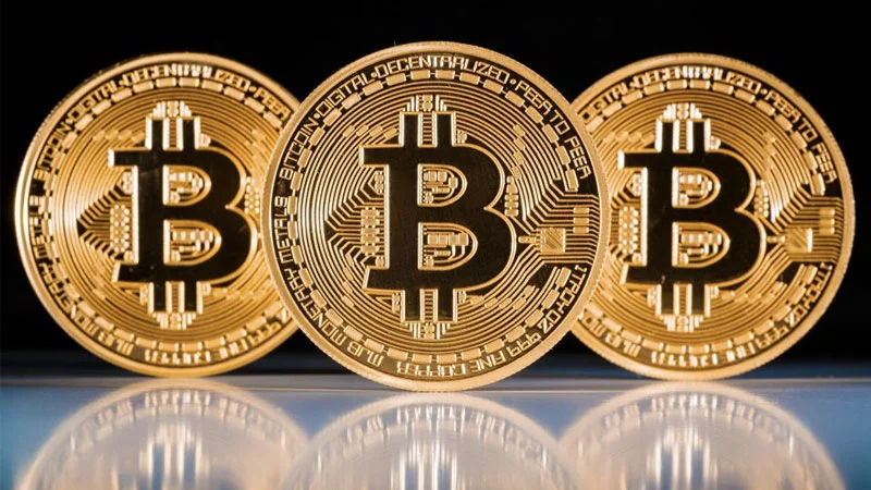 Physical commemorative Bitcoin coins featuring the iconic 'B' symbol, often used as visual shorthand for the cryptocurrency.