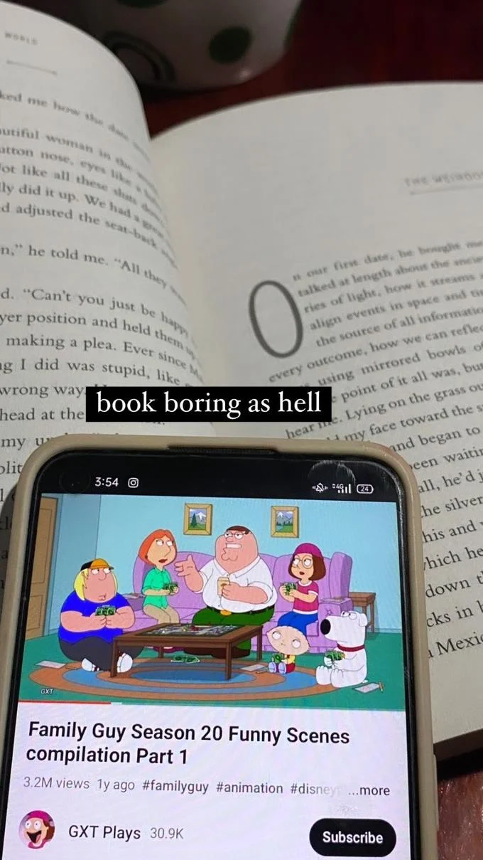 A reader dismisses their book as 'boring as hell' while watching a Family Guy compilation on their phone.