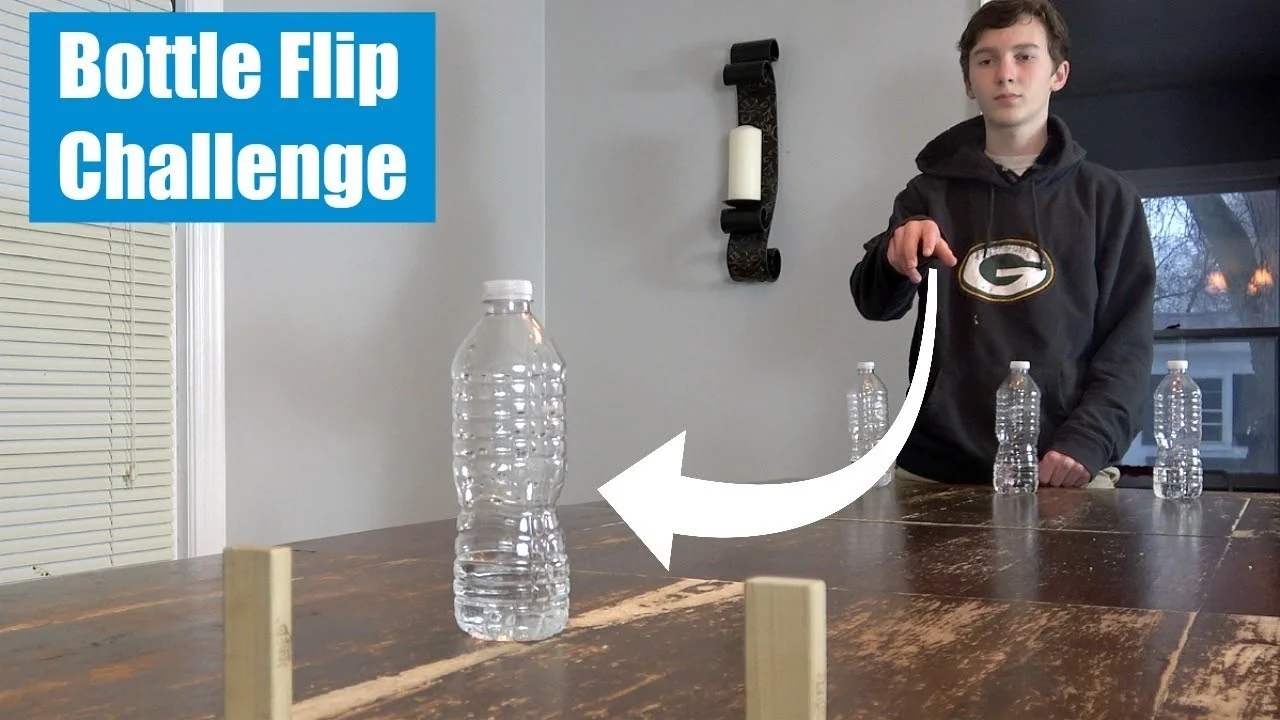 Person demonstrating bottle flip challenge with instructional arrows pointing at water bottle on table
