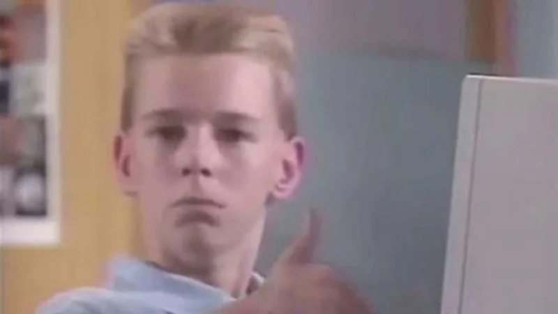 The signature thumbs-up frame from the 1990s Apple education promo featuring Brent Rambo, the shot that became the definitive still image of the meme.