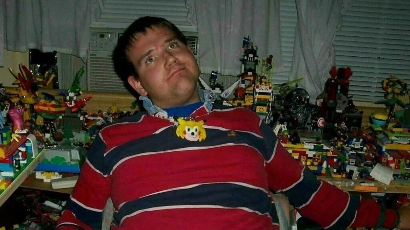 Christian Weston Chandler in his infamous Sonichu medallion and striped rugby shirt, seated in his Lego-filled bedroom.