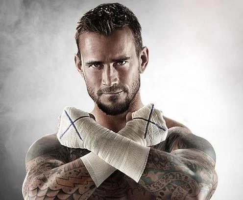 CM Punk in a signature promotional shot with his tape-wrapped 'straight edge' X hands crossed.