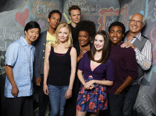 The Community ensemble cast posed for a promotional group shot in front of the Greendale study room chalkboard.