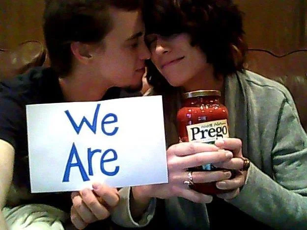 A couple announces their pregnancy by holding a 'We Are' sign alongside a jar of Prego pasta sauce.