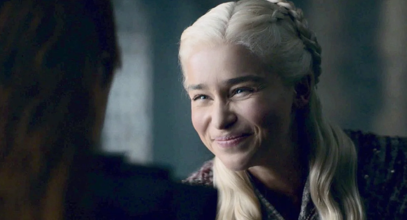 The original Game of Thrones scene from Season 8 that spawned the 'Daenerys Targaryen Squint' meme, featuring Emilia Clarke's tight, forced smile.