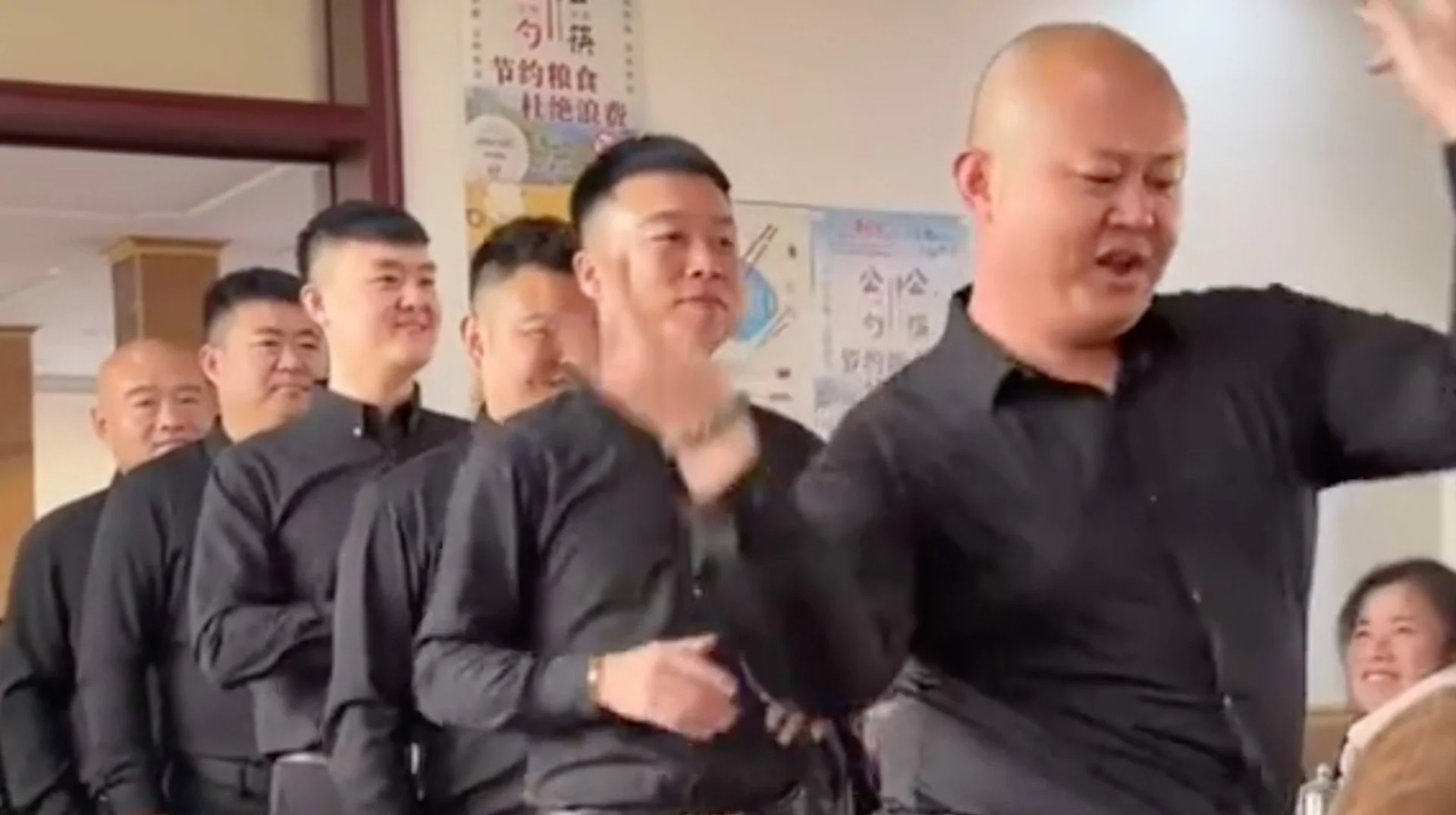 Screenshot from the viral video of Chinese restaurant staff performing a synchronized dance routine that spawned the 'dancing Chinese waiters' meme.