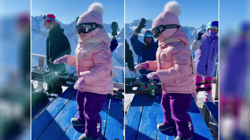 The iconic Dancing Ski Baby in pink jacket at mountain resort.