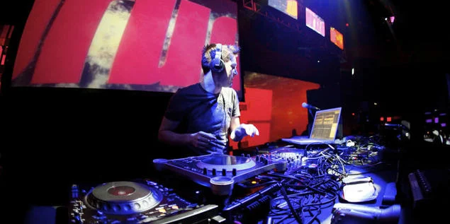 DJ Darude performing on stage with professional lighting.