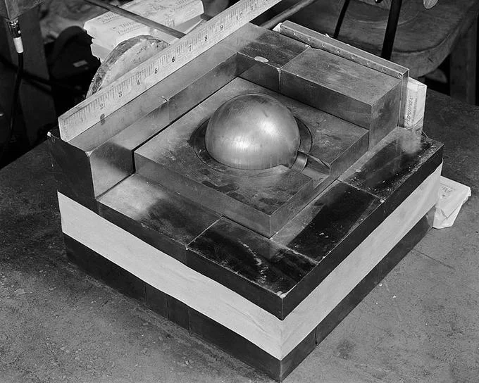 Reconstruction photograph of Harry Daghlian's August 1945 criticality accident setup involving the plutonium 'demon core' and tungsten carbide bricks.