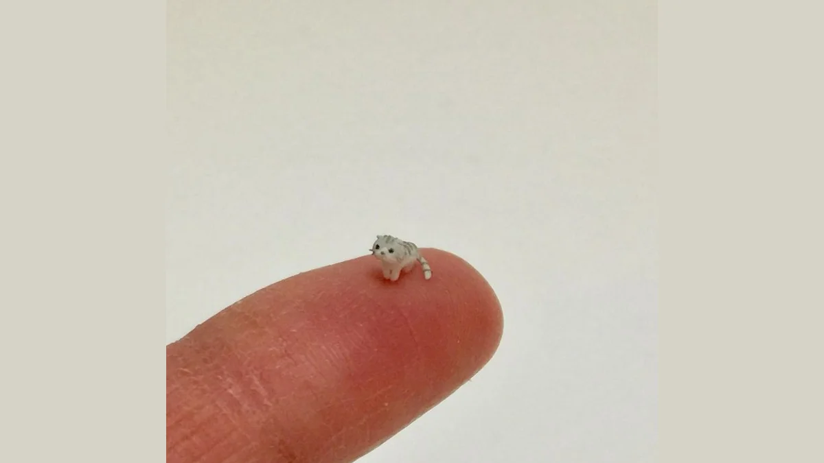 The cover image for the 'el wiwi' meme, showing the miniature gray cat figurine balanced on a fingertip that inspired the viral format.