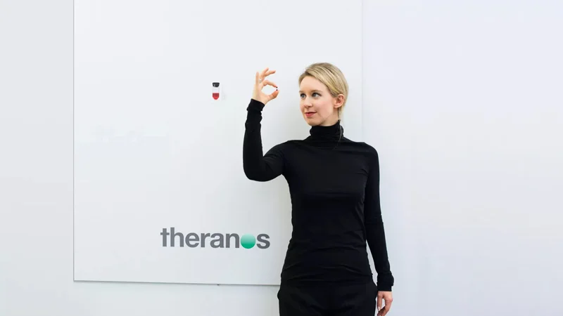 Theranos founder Elizabeth Holmes poses with the company's nanotainer blood collection device, the miniature vial that was central to the startup's fraudulent blood-testing claims.