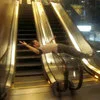 Classic Escalator Spin pose between opposing handrails in shopping mall.