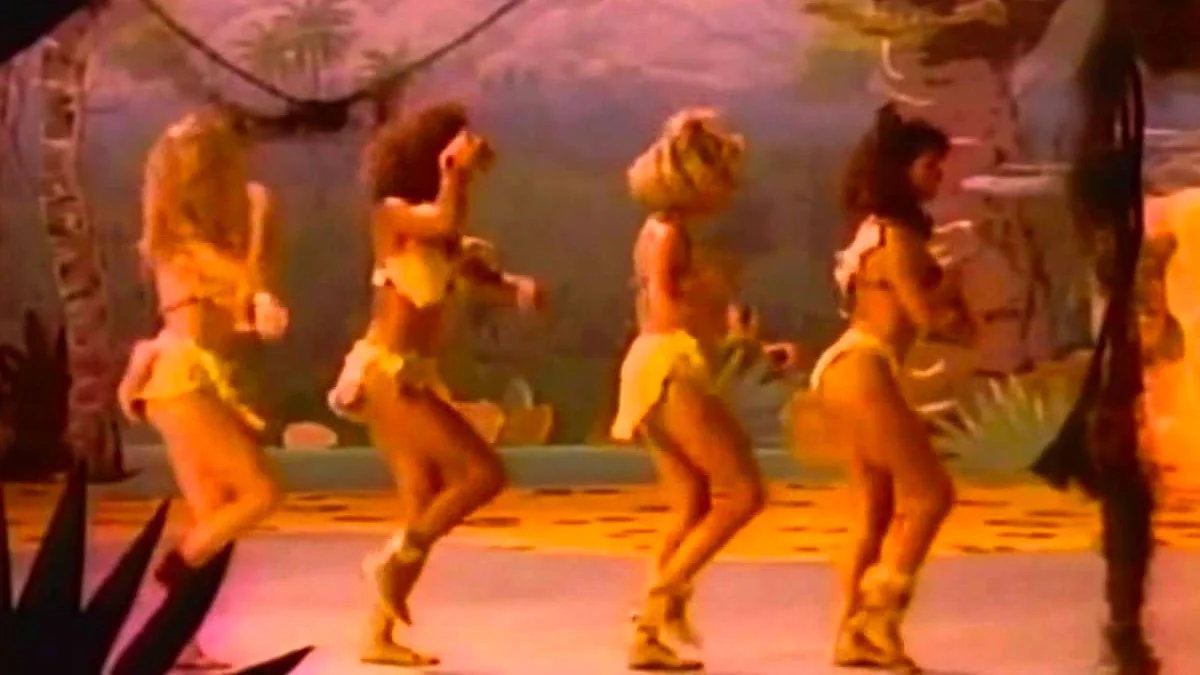 A scene from the iconic 1987 'Walk the Dinosaur' music video by Was (Not Was), the source of the meme's title lyric.