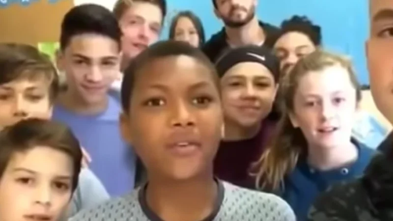 The original video still that spawned the 'Everyone, we have an announcement to make' meme, featuring a boy flanked by his peers.