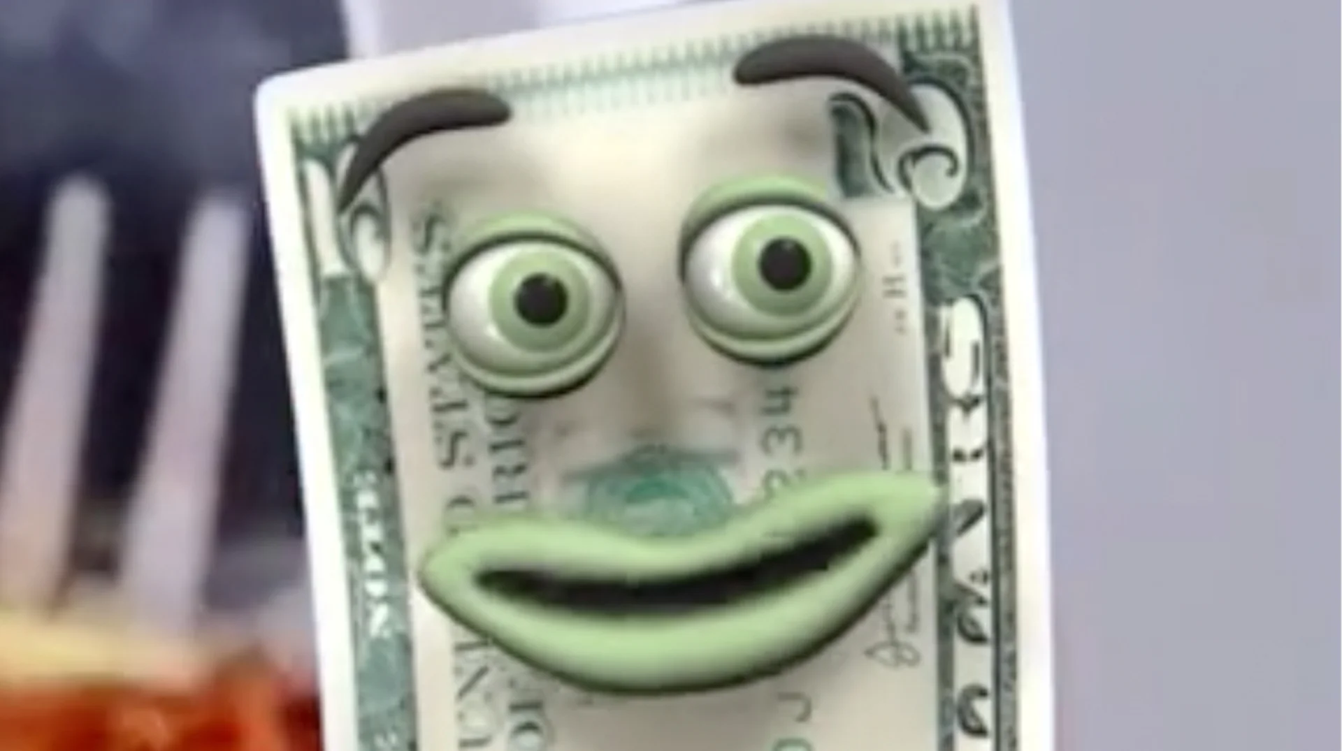 A close-up still of Fiveish, the anthropomorphic five-dollar bill mascot featured in the Yap Dollar commercial that inspired the meme.