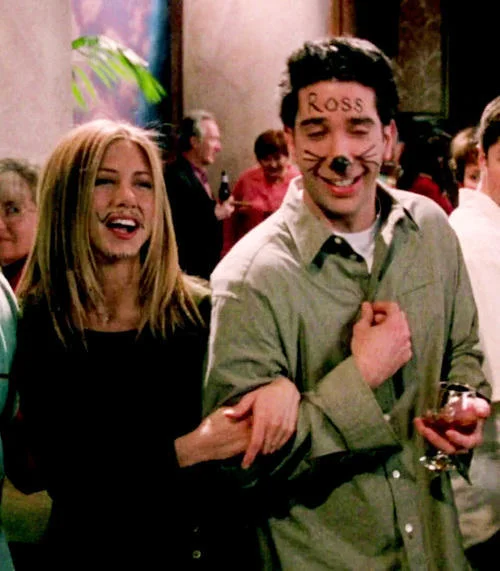 Rachel laughs beside Ross after his face was doodled on with a marker in the classic 'Ross gets drawn on' scene.
