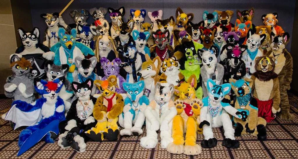 Fursuiters gathered for a group photo at a furry convention, showcasing the diversity of anthropomorphic character designs within the fandom.