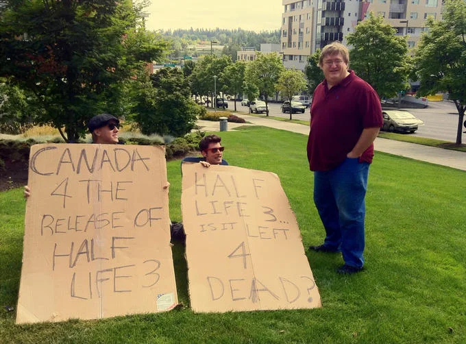 Fans confront Valve's Gabe Newell with cardboard signs pleading for the release of the long-awaited Half-Life 3.