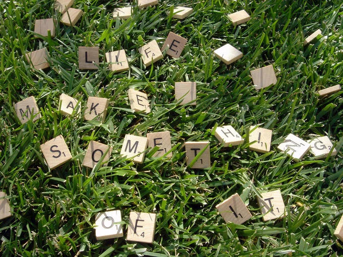 Scrabble tiles, from Hasbro's classic word game, arranged on grass to spell an inspirational phrase.