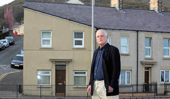 House with person for scale revealing architectural facial features.