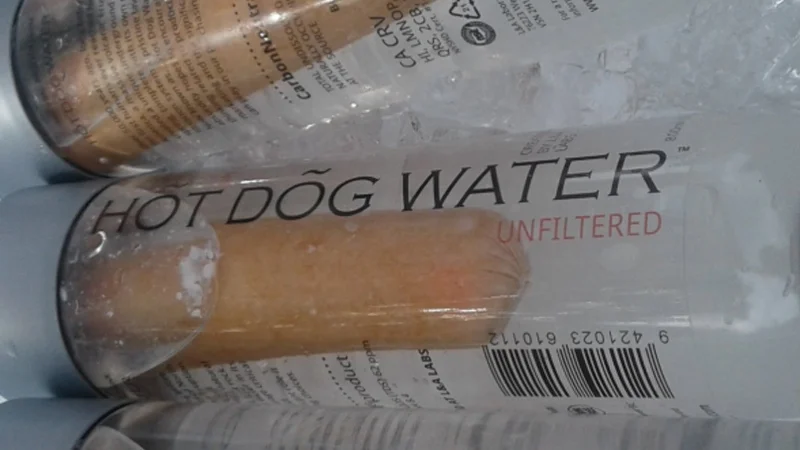 The infamous 'Hot Dog Water Unfiltered' bottle featuring an actual hot dog submerged in water, sold as a satirical health product.
