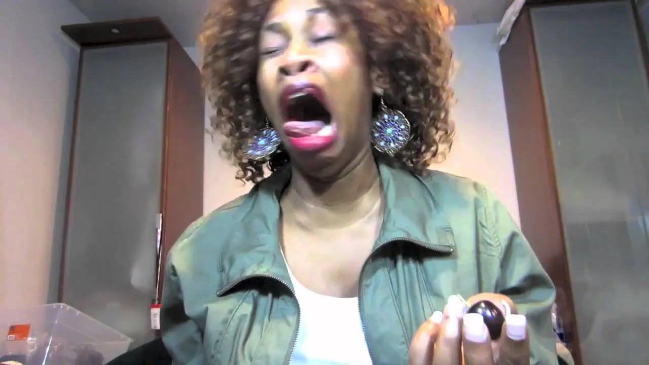 A YouTuber grimaces in reaction to the intense heat while participating in the hot pepper challenge.
