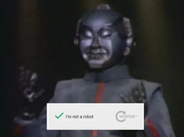 A retro sci-fi robot successfully passes the 'I'm not a robot' verification, playing on the meme's core irony.