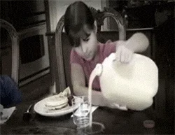 Child struggling with large heavy pitcher.