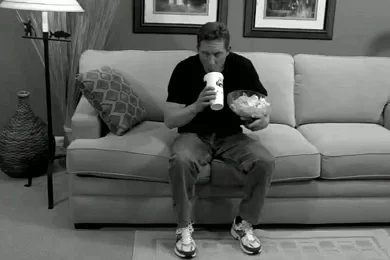 Man struggling with eating tasks on couch.