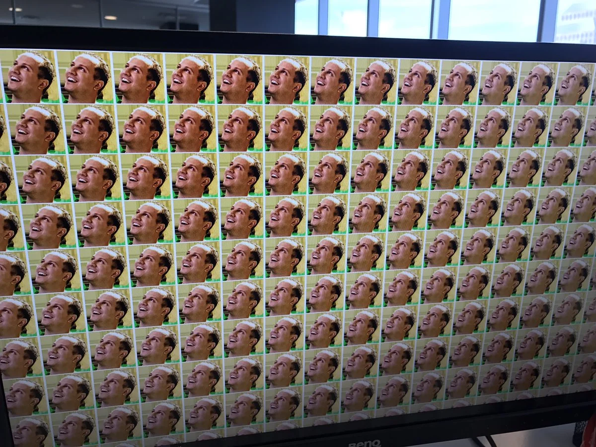 Alex Jebailey, the man behind the Jebaited emote, tweeting a photo of a monitor displaying a wallpaper tiled entirely with his own emote face.