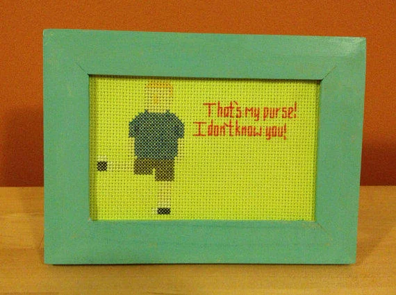 A fan-made cross-stitch featuring Peggy Hill's iconic "That's my purse!" quote from King of the Hill.