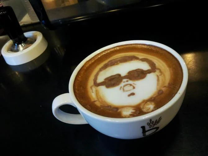 A latte art tribute to Psy's 'Gangnam Style,' complete with his signature sunglasses etched into the crema.