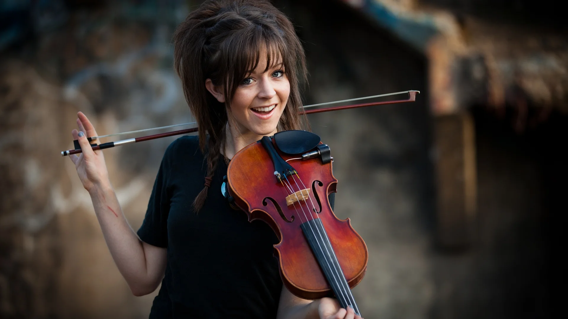 Lindsey Stirling posing with her violin, the signature instrument that defined her dance-driven performance style.