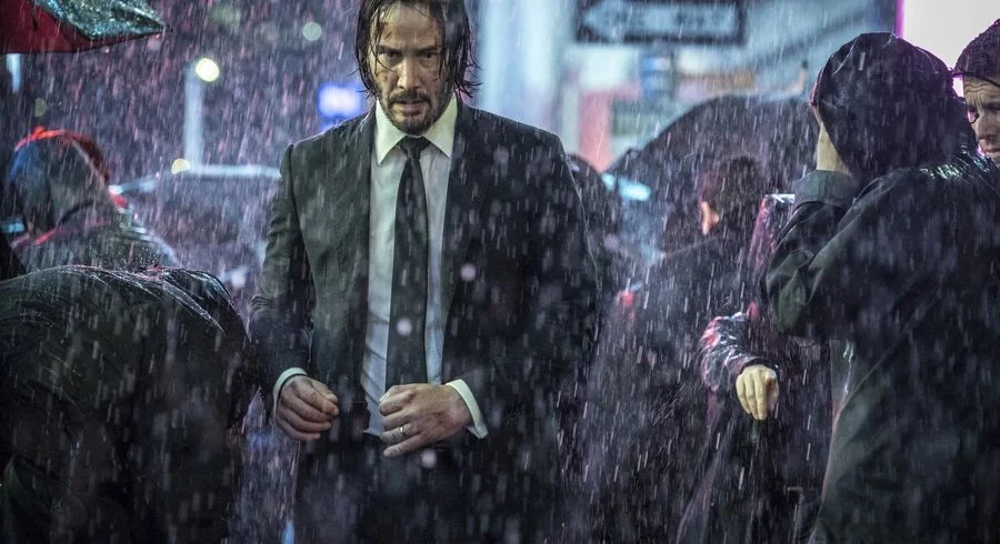 A cinematic still of Keanu Reeves that captures the melancholic, solitary aura fans associate with the 'Lonely Keanu' meme.