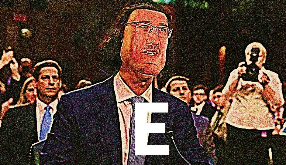 The original 'E' meme image, combining Markiplier's face on Mark Zuckerberg's Congressional hearing photo, deep-fried and stamped with a large white 'E'.