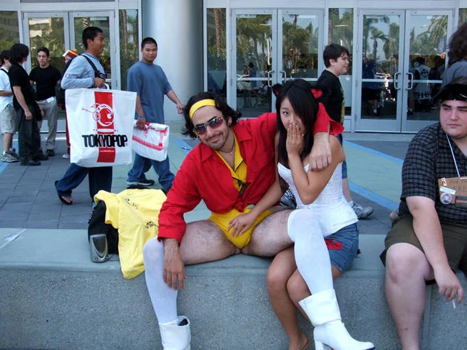 Man-Faye poses with a female Faye Valentine cosplayer at an anime convention, showcasing his hairy-legged rendition of the character.