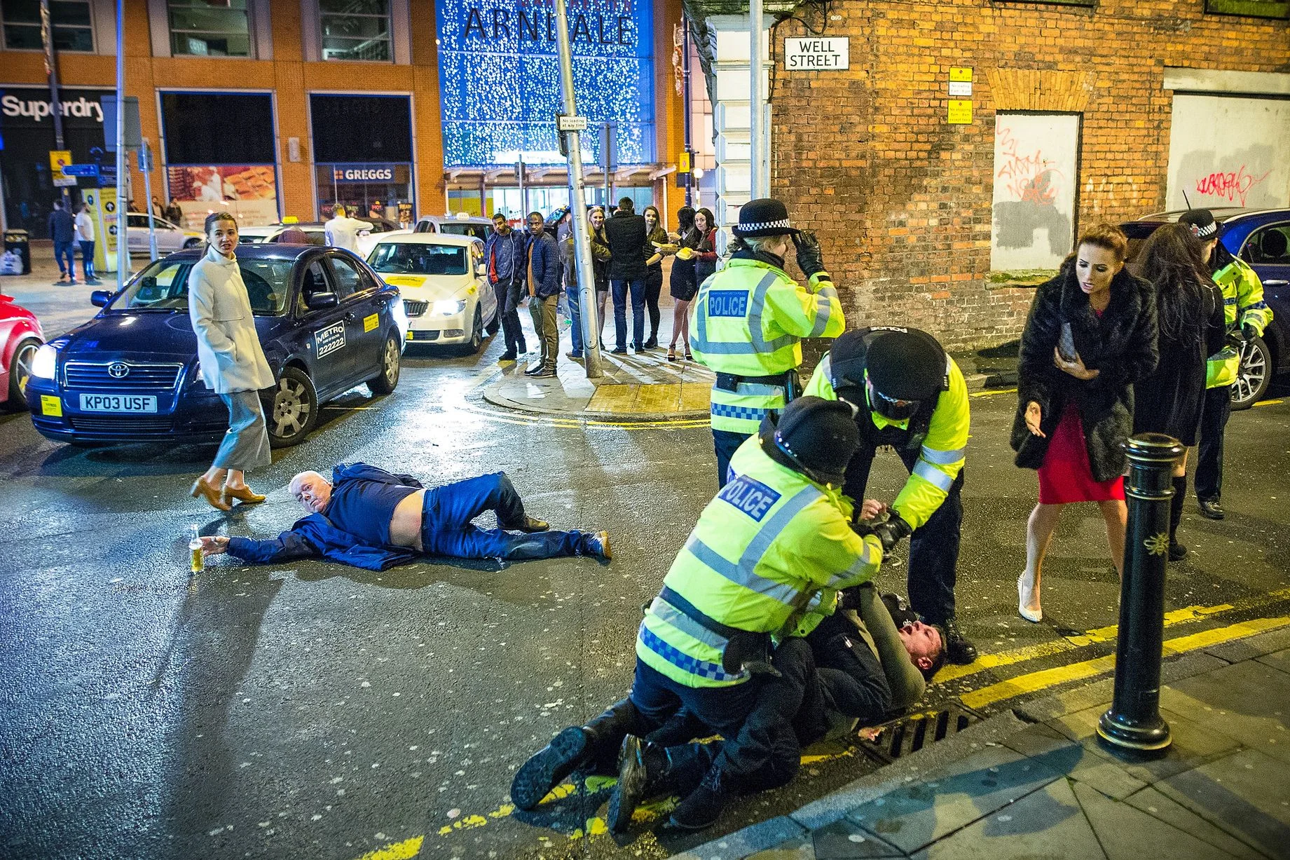 The original 'Manchester New Year's Eve' photograph by Joel Goodman for the Manchester Evening News, capturing a chaotic street scene on January 1, 2016.