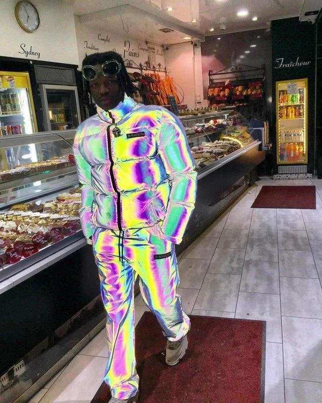 The original viral photograph of a man in a rainbow-reflective tracksuit that became the source image for the diamond-armor parody edit.